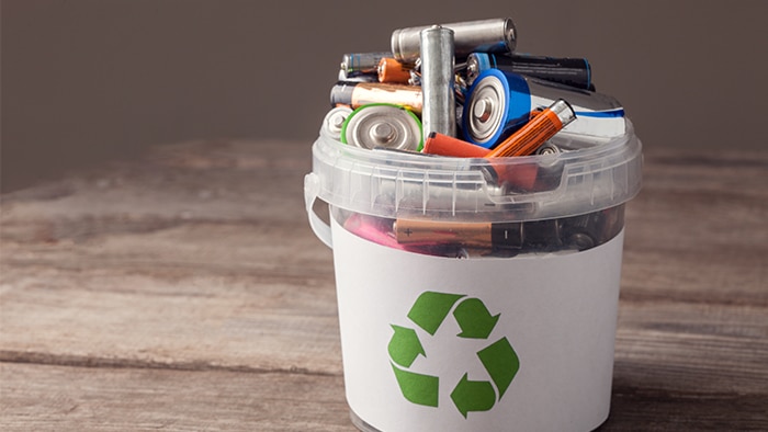 A photo of a recycling bucket that is filled with alkaline batteries