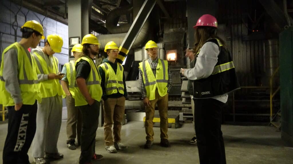 ecomaine educator Bea Johnson leads a tour for students of Baxter Academy, positioned in front of one of the boilers in ecomaine's Waste to Energy facility