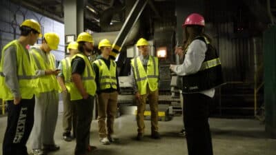 ecomaine educator Bea Johnson leads a tour for students of Baxter Academy, positioned in front of one of the boilers in ecomaine's Waste to Energy facility